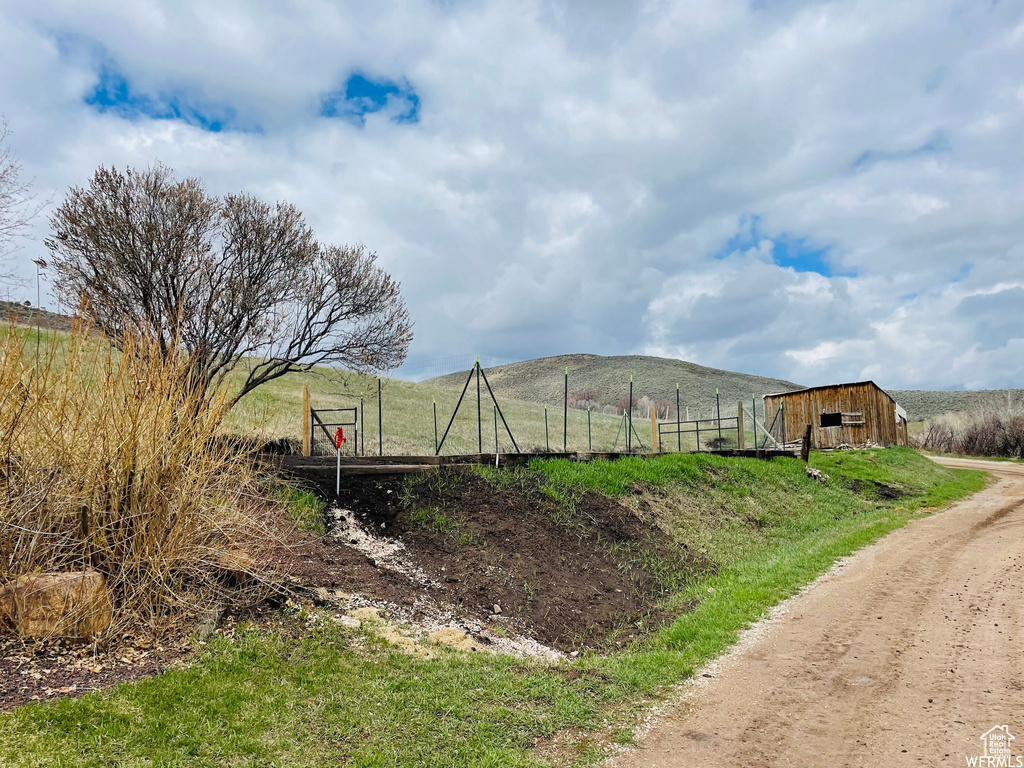 View of yard featuring a rural view, a mountain view, and an outbuilding