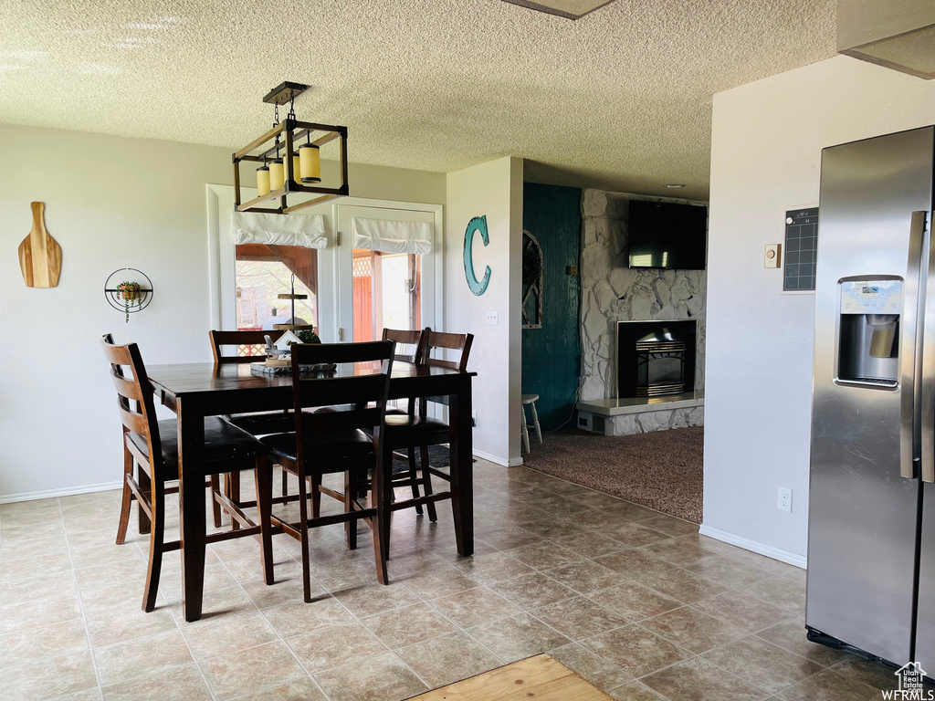 Dining area featuring a fireplace and a textured ceiling