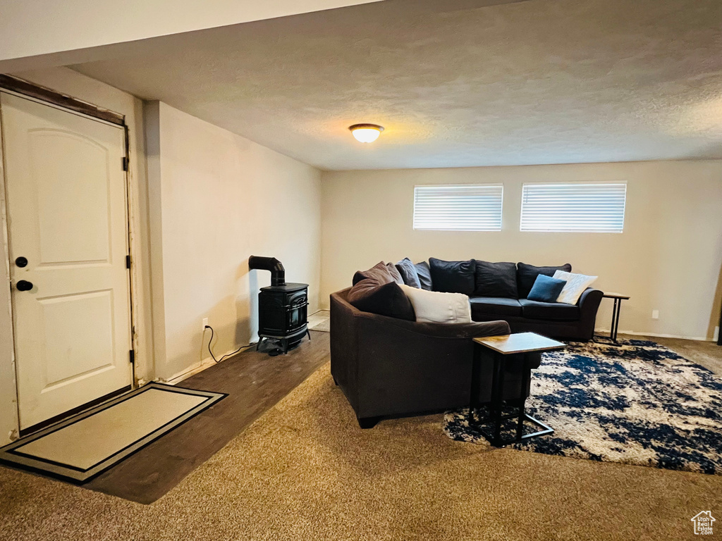 Living room featuring hardwood / wood-style floors, a textured ceiling, and a wood stove