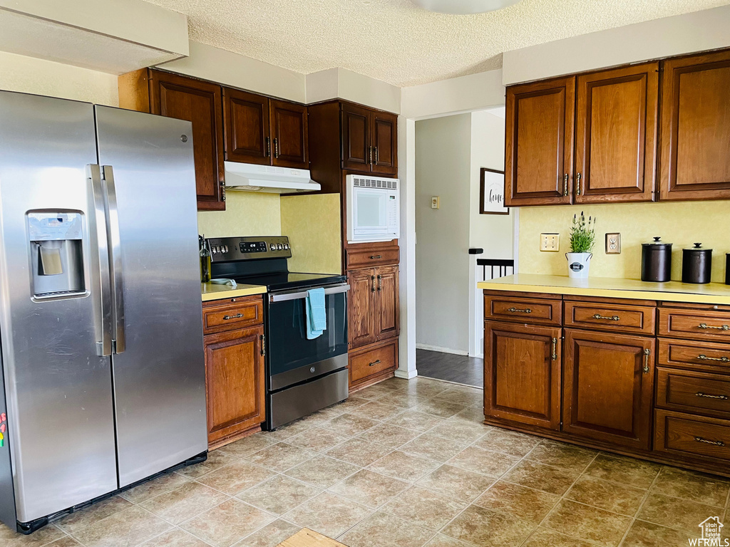 Kitchen featuring appliances with stainless steel finishes and a textured ceiling