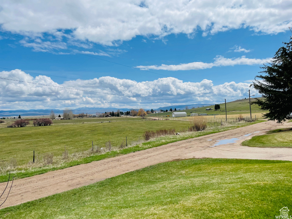 View of property\\\\\\\'s community with a mountain view, a yard, and a rural view