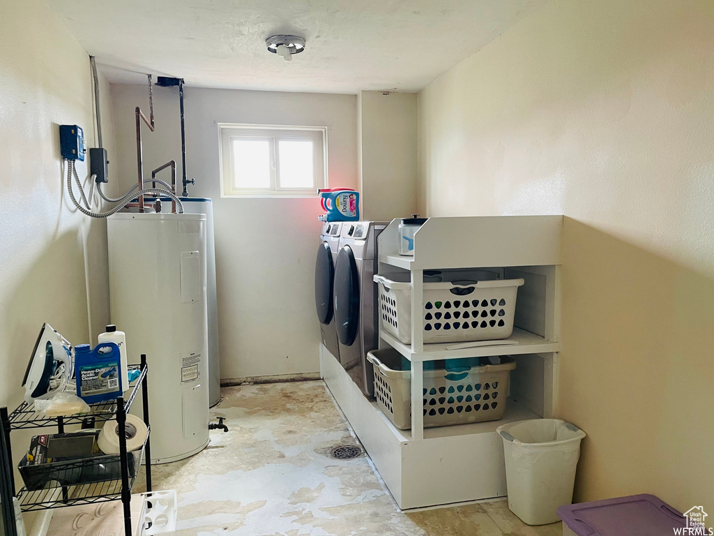 Clothes washing area featuring washing machine and clothes dryer and water heater