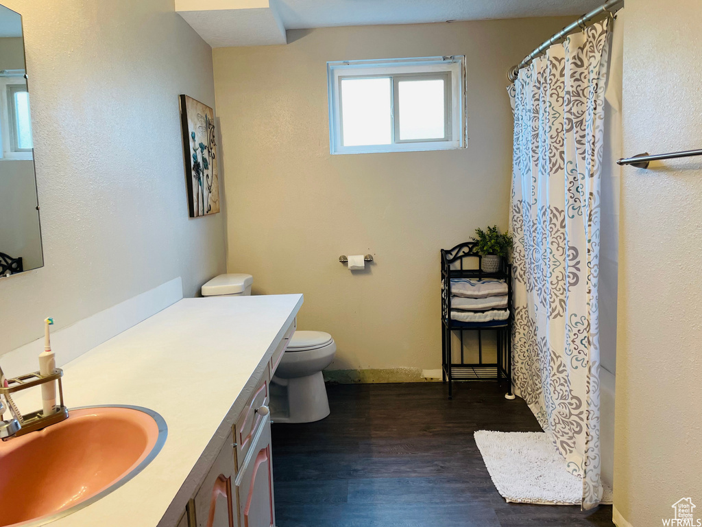 Bathroom with vanity, hardwood / wood-style floors, toilet, and a shower with shower curtain