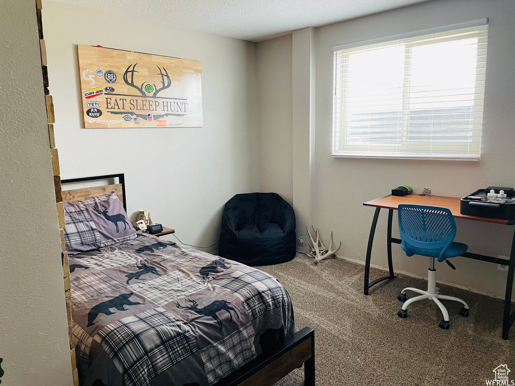 Bedroom with carpet floors and a textured ceiling