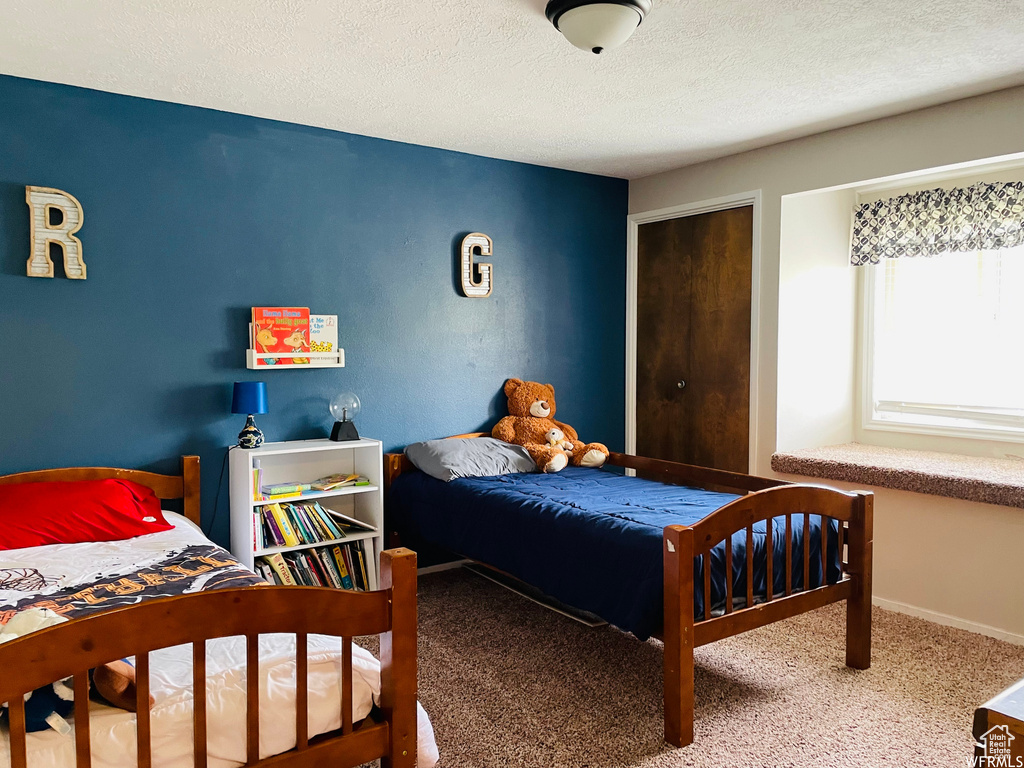 Bedroom featuring carpet flooring and a textured ceiling