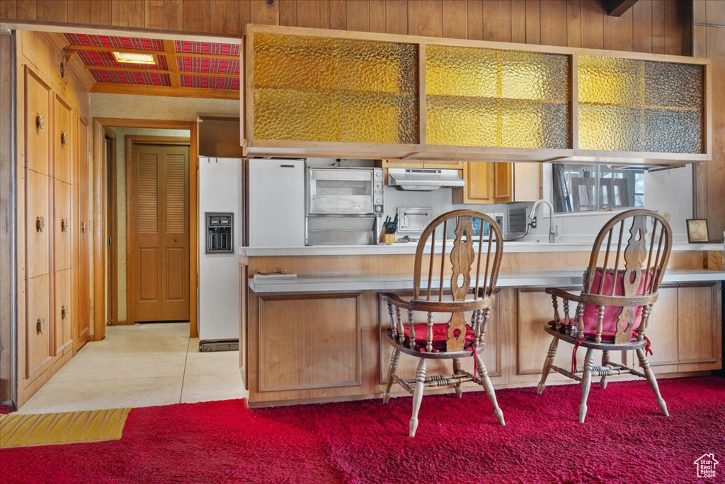 Kitchen featuring white refrigerator with ice dispenser