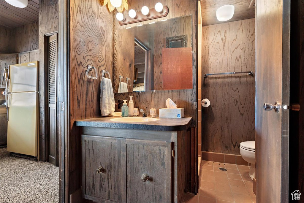 Bathroom featuring vanity, toilet, and tile patterned flooring