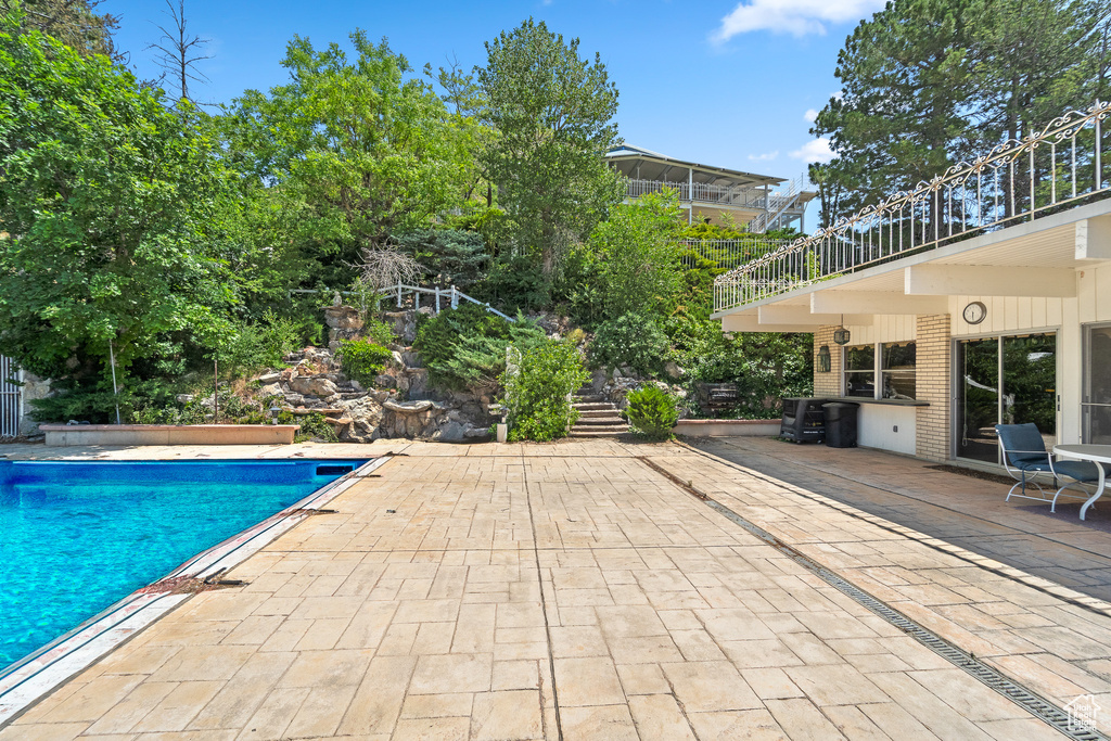 Swimming pool with a patio area and stairway