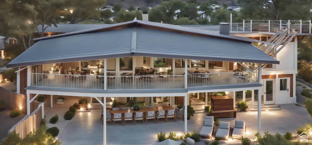 Rear view of house with a patio and a balcony