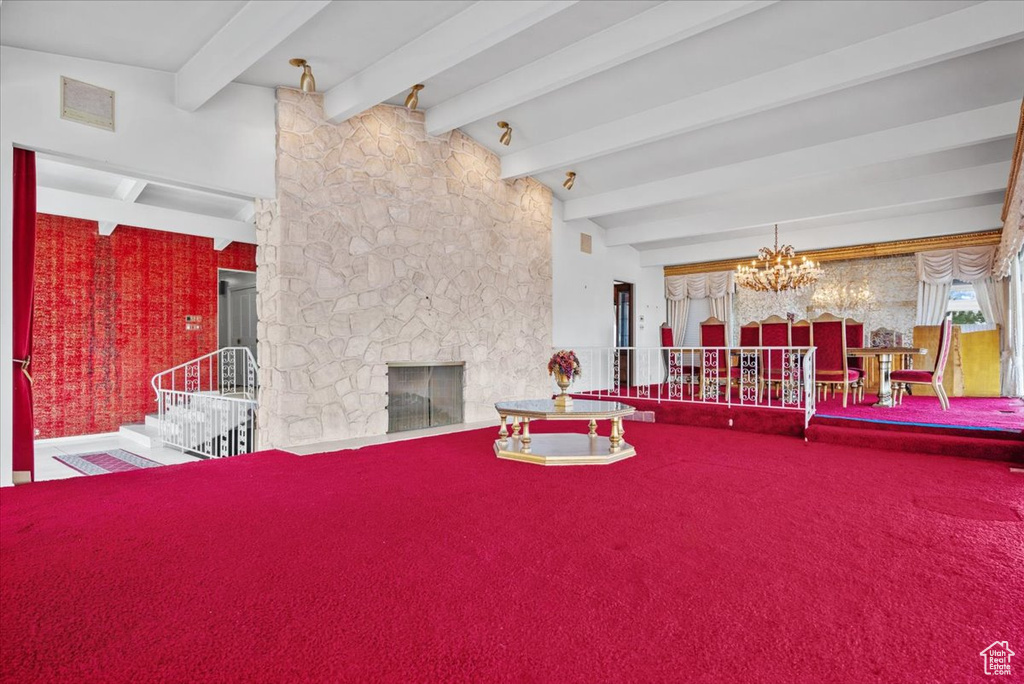 Dining room with beamed ceiling, carpet flooring, a fireplace, and an inviting chandelier