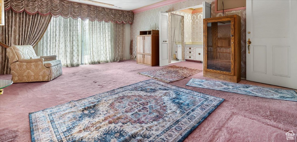 Interior space featuring ornamental molding and carpet flooring