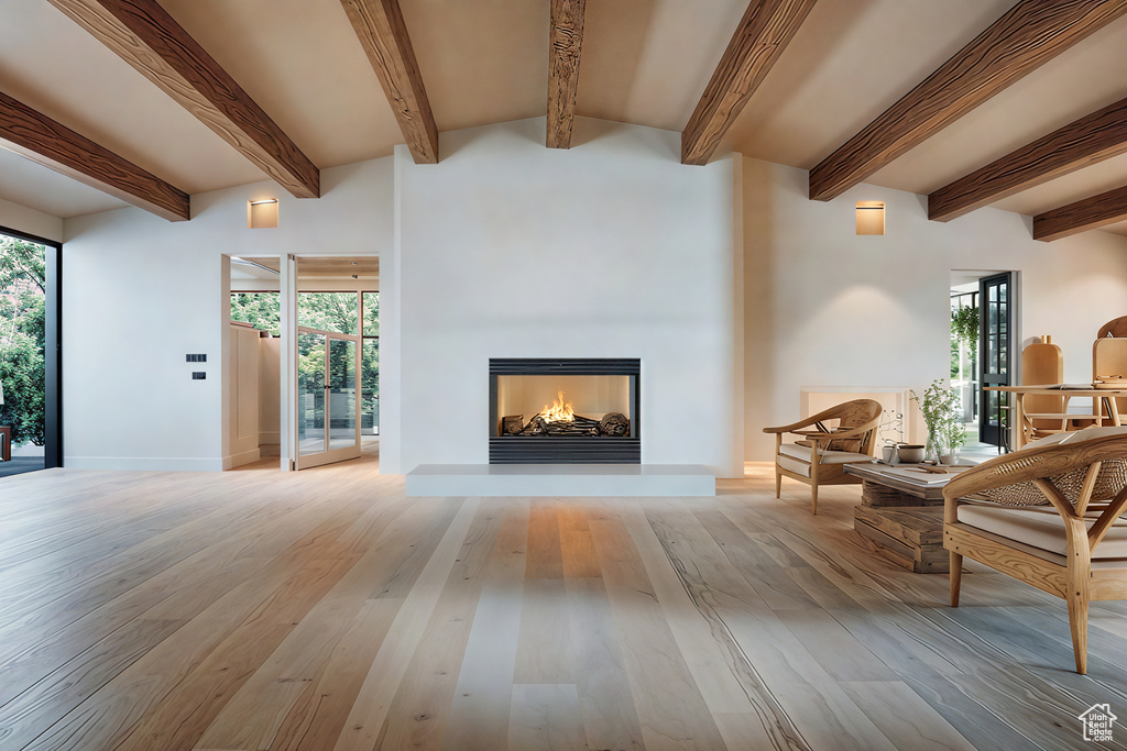 Living room featuring beam ceiling, a wealth of natural light, and light hardwood / wood-style floors
