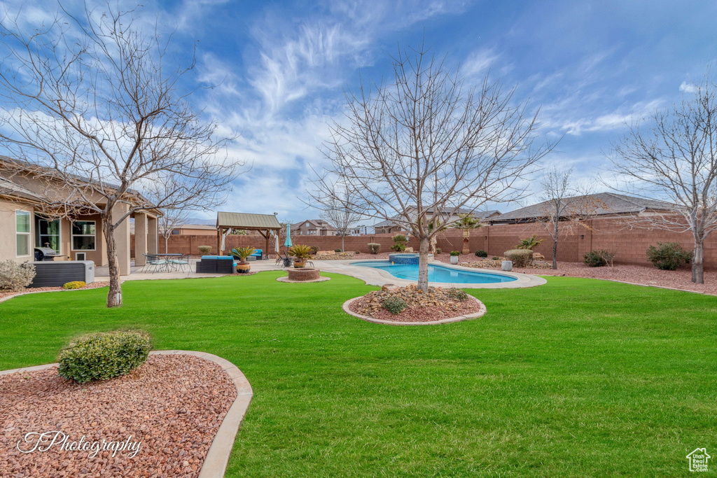 View of yard with an outdoor hangout area, central AC unit, a fenced in pool, a gazebo, and a patio area