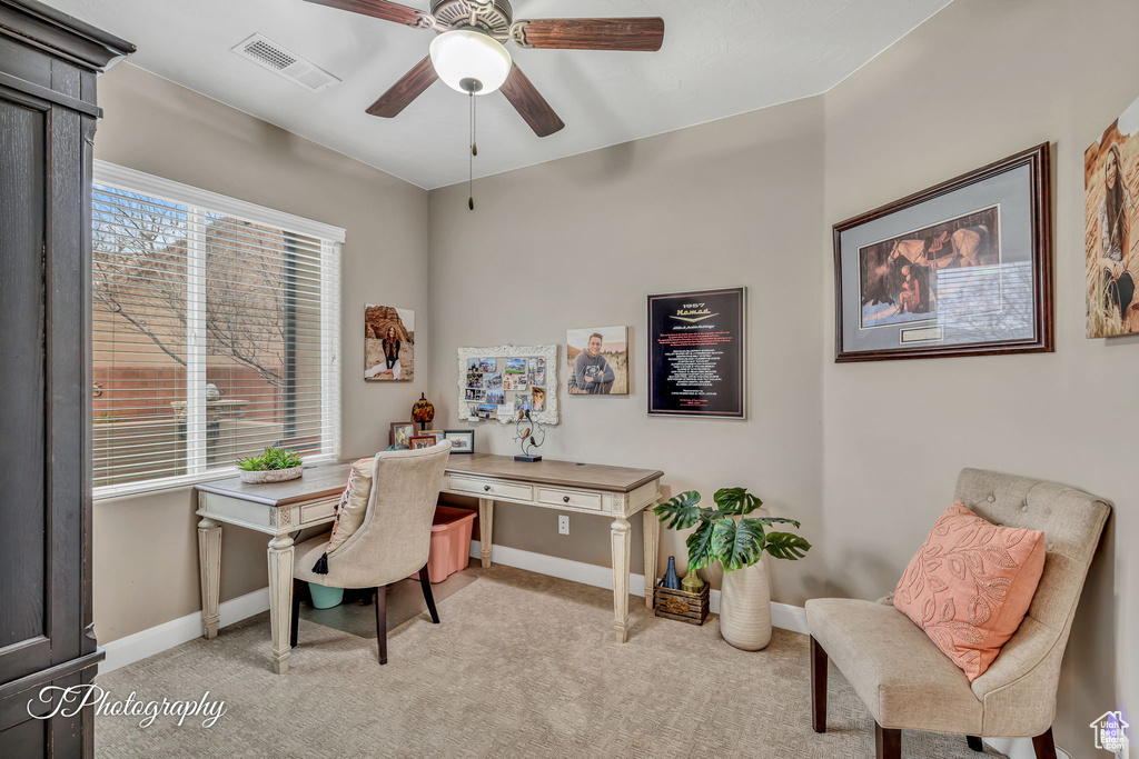 Office space with light colored carpet and ceiling fan