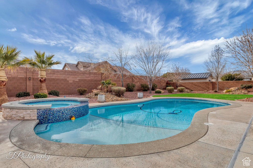 View of swimming pool with an in ground hot tub