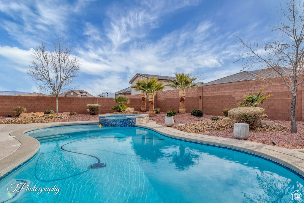 View of swimming pool featuring an in ground hot tub