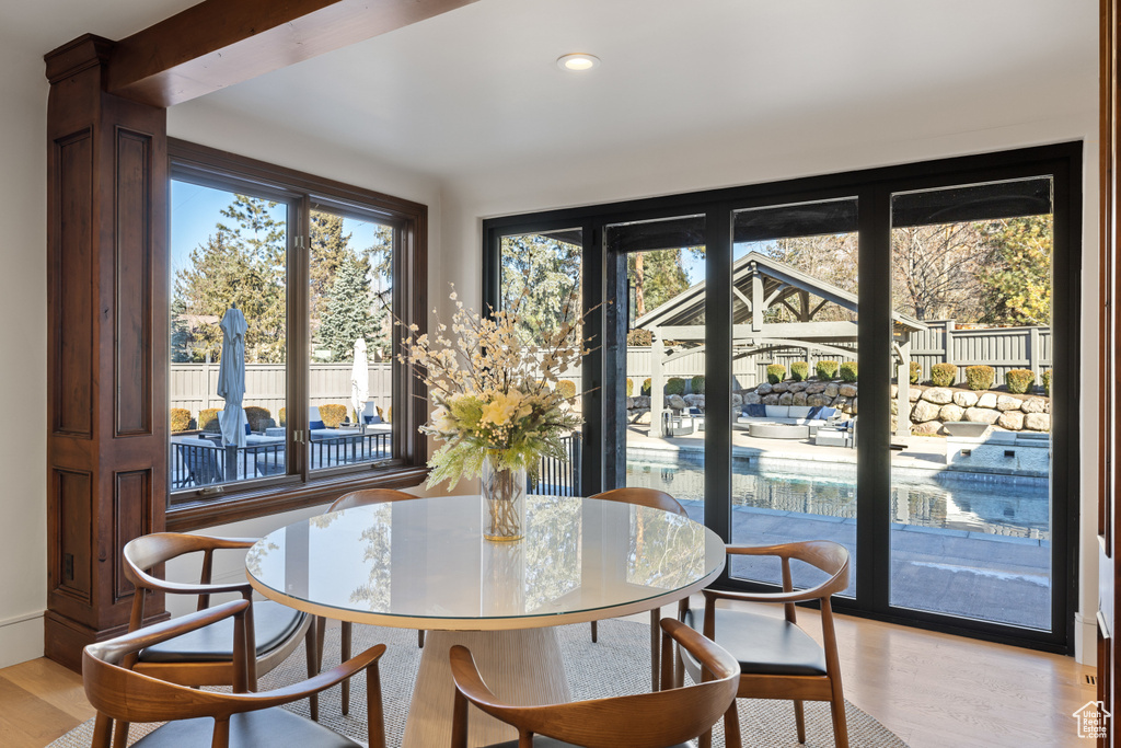 Dining area with light wood-style flooring and recessed lighting