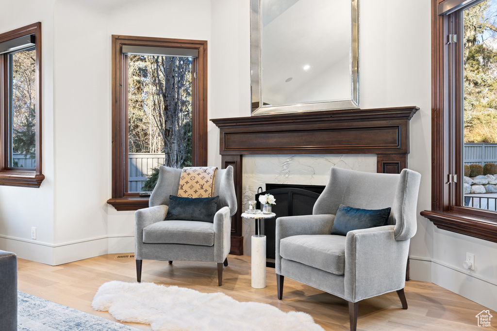 Sitting room featuring wood finished floors and a high end fireplace