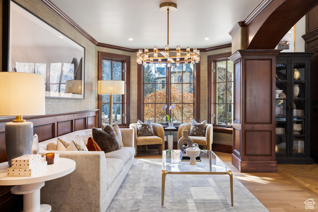 Living room with a chandelier, ornamental molding, and recessed lighting