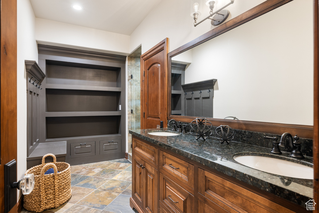 Full bath featuring double vanity and built in shelves