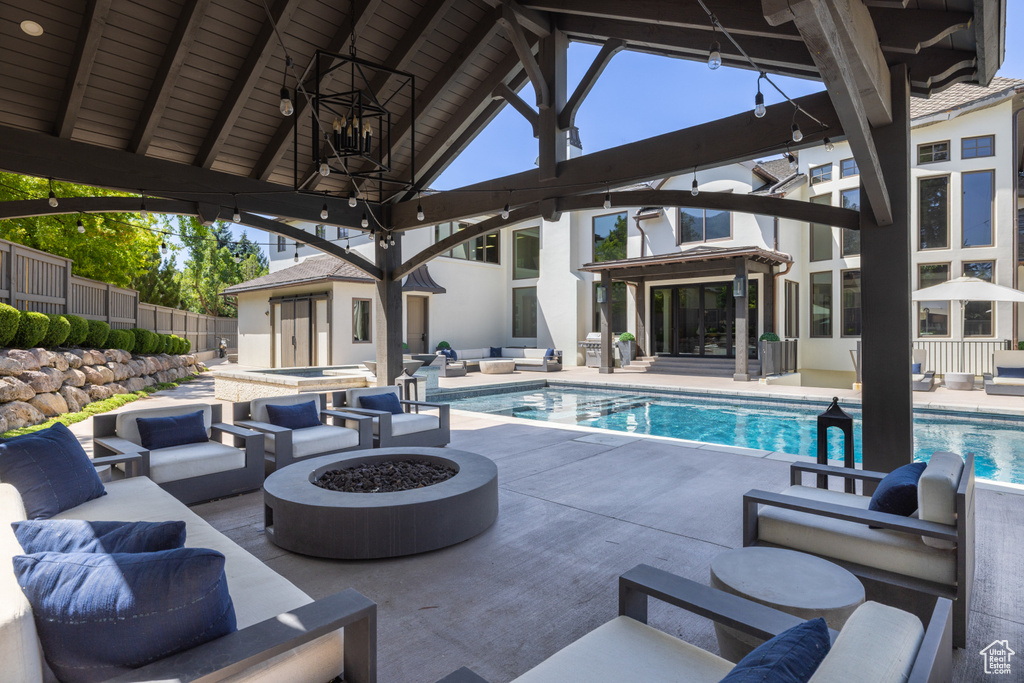 View of swimming pool featuring an outdoor living space with a fire pit, a patio area, and a gazebo