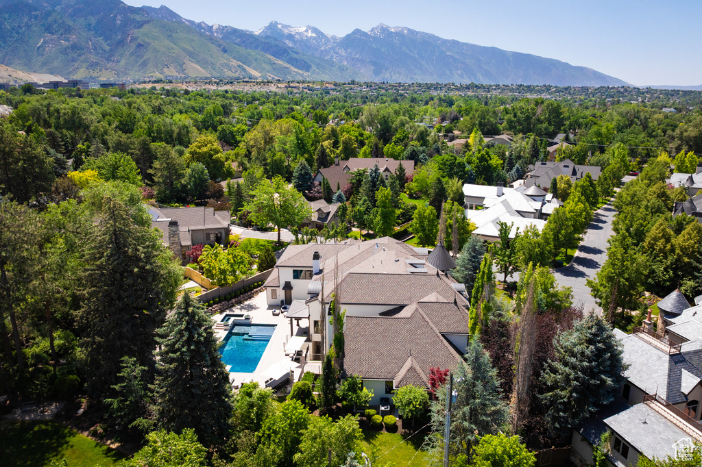 Aerial perspective of suburban area featuring a mountain backdrop and a pool