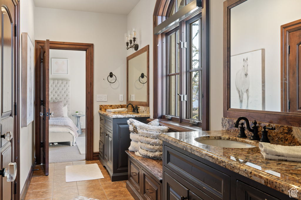 Ensuite bathroom featuring two vanities and tile patterned floors