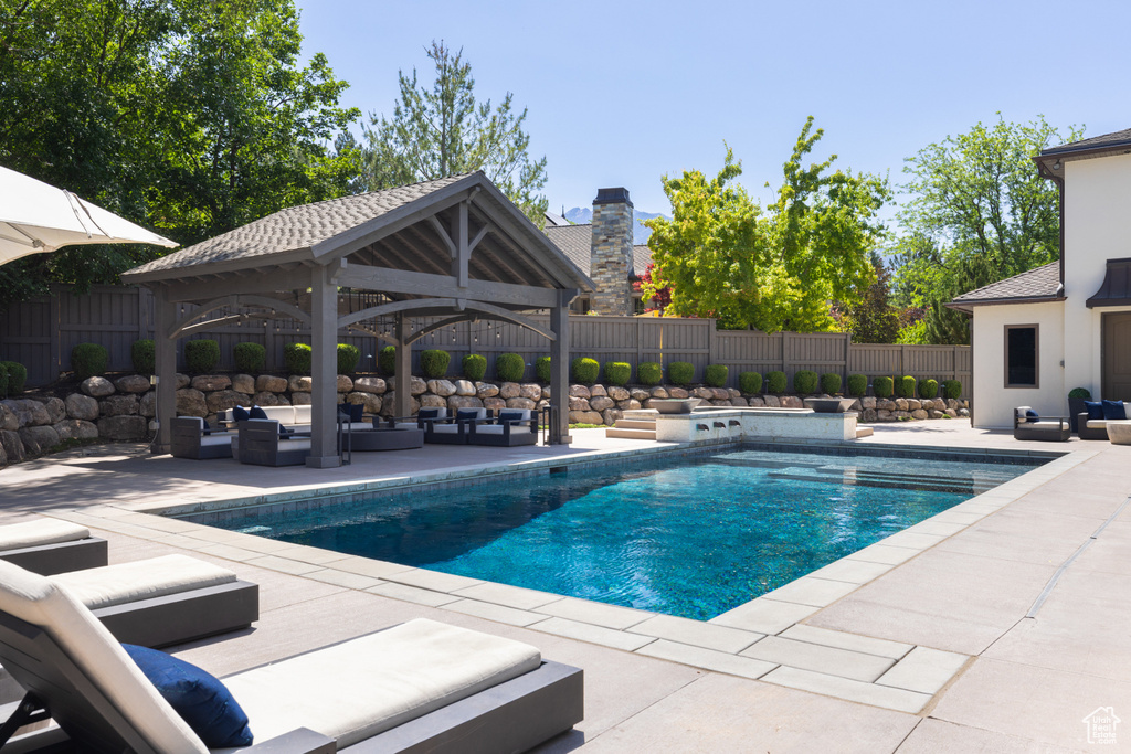 View of pool with an outdoor living space, a gazebo, a patio area, and a fenced backyard
