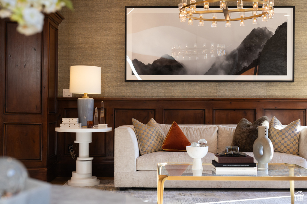 Detailed view of a chandelier, wainscoting, wallpapered walls, and a decorative wall