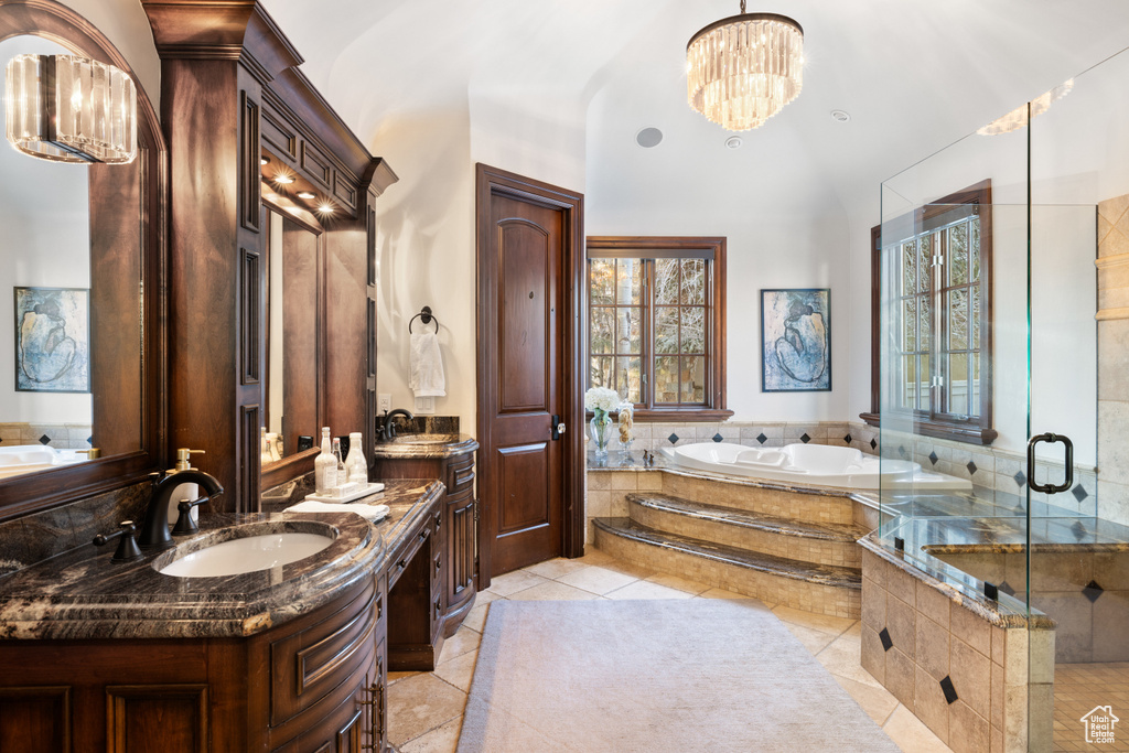Full bathroom featuring a chandelier, a bath, vanity, and a shower stall
