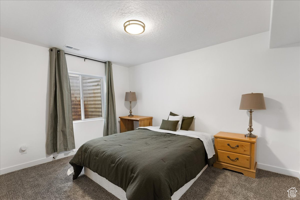 Carpeted bedroom featuring a textured ceiling