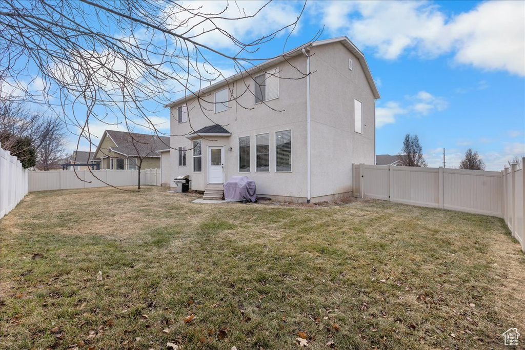 Rear view of property with a lawn