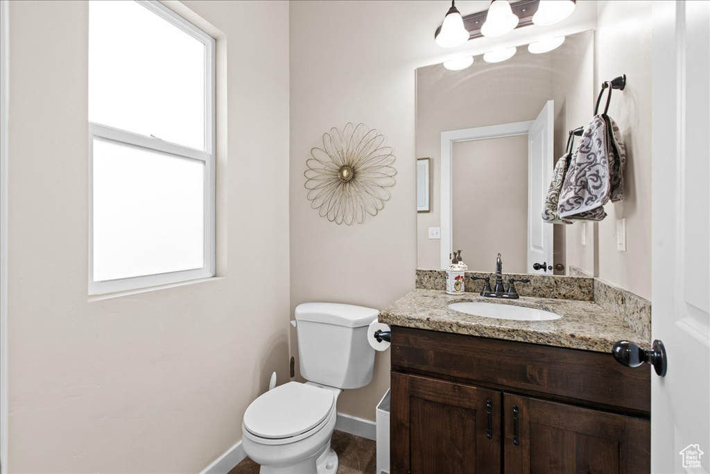 Bathroom with vanity, a wealth of natural light, and toilet