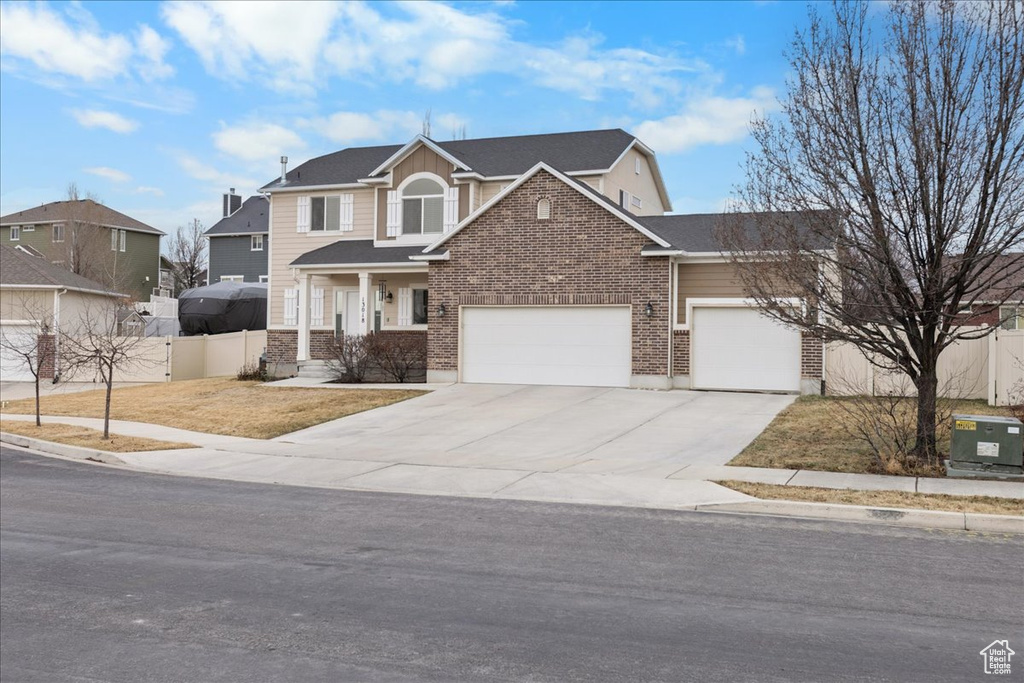 View of front of home with cooling unit and a garage