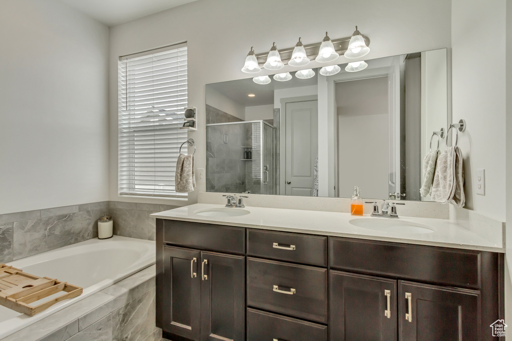 Bathroom with shower with separate bathtub, a healthy amount of sunlight, and vanity