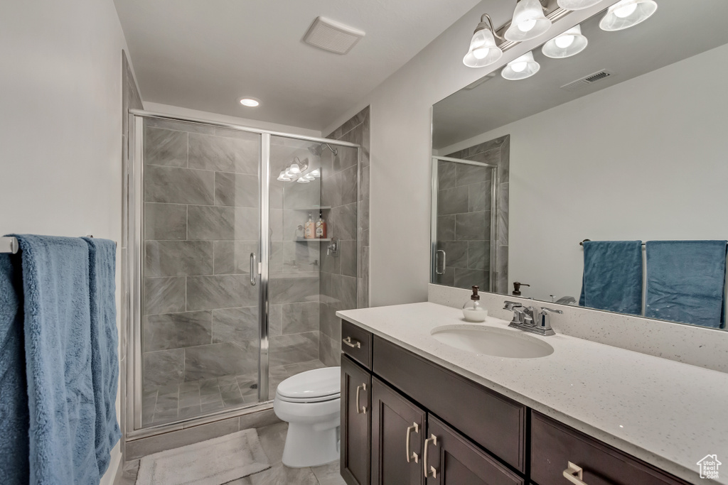 Bathroom with vanity, toilet, and a shower with door
