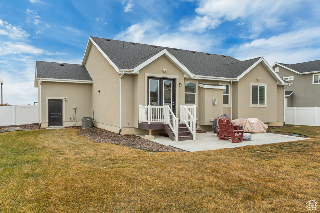 Back of house with a yard, central AC, and a patio