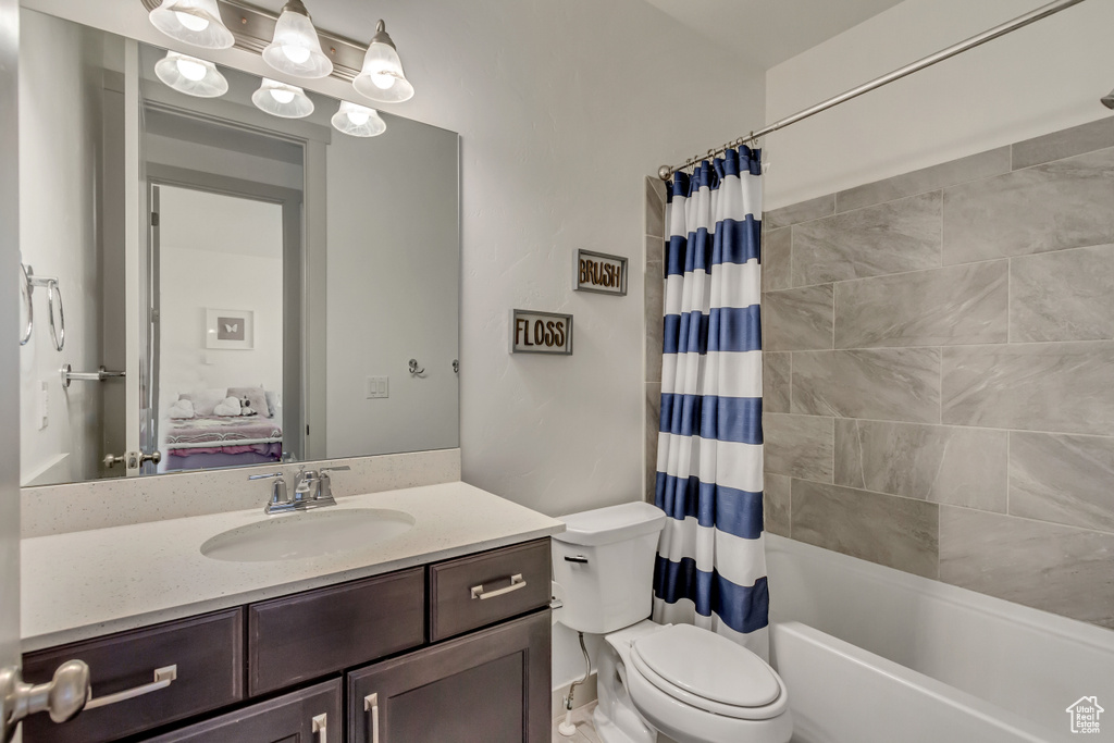 Full bathroom with vanity, shower / bath combination with curtain, and toilet