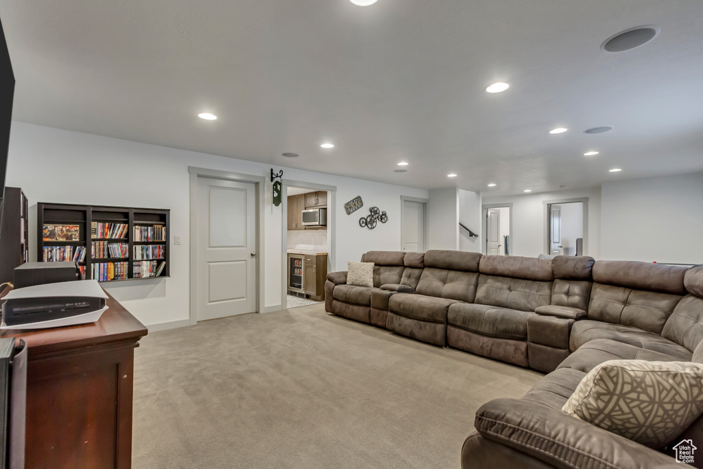 Carpeted living room featuring beverage cooler and bar area