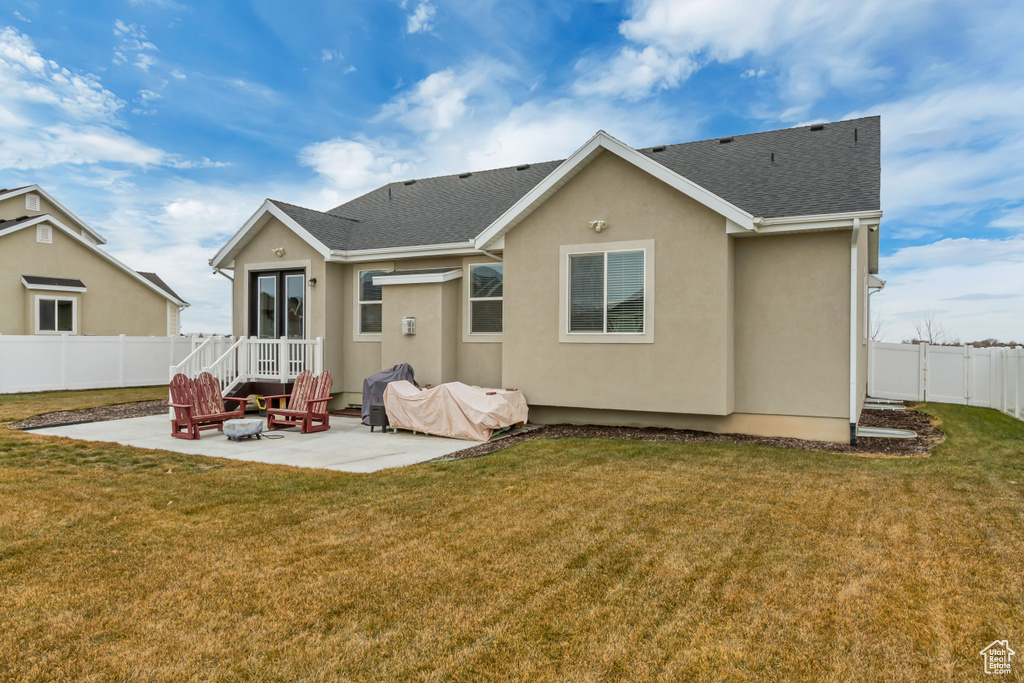 Back of property with a patio area and a lawn
