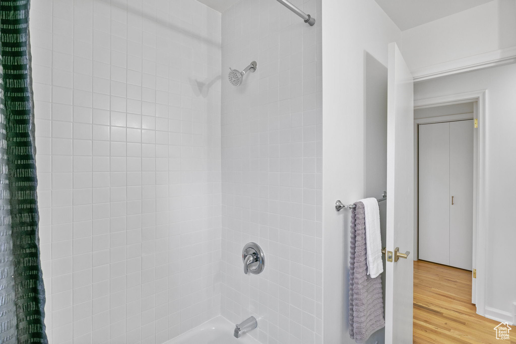 Bathroom with wood-type flooring and shower / bath combo