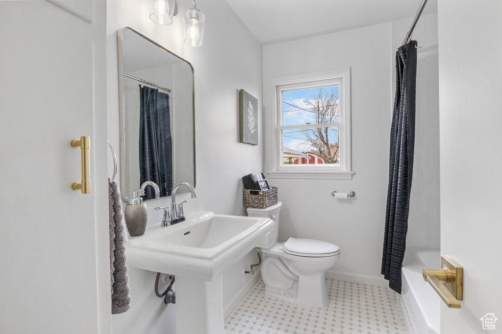 Bathroom with shower / bath combination with curtain and toilet