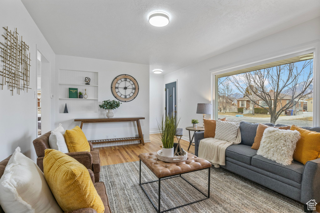 Living room with a textured ceiling and light wood-type flooring