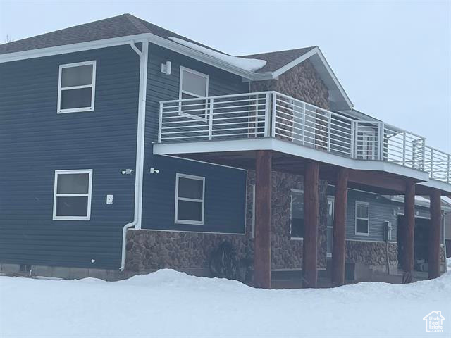 View of snowy exterior with a balcony