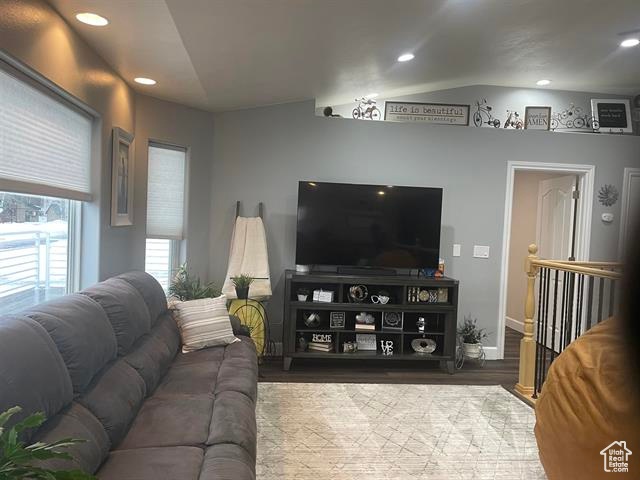 Living room with lofted ceiling and hardwood / wood-style flooring