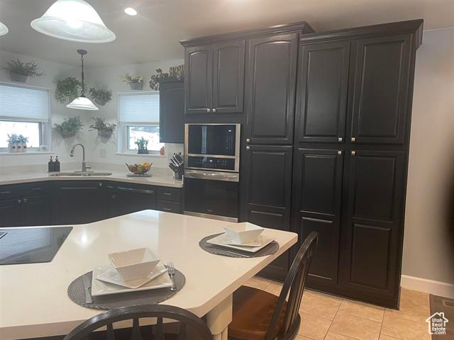 Kitchen featuring pendant lighting, sink, a healthy amount of sunlight, and stainless steel oven