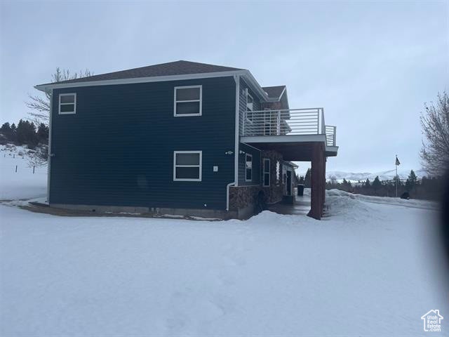 View of snowy exterior featuring a balcony