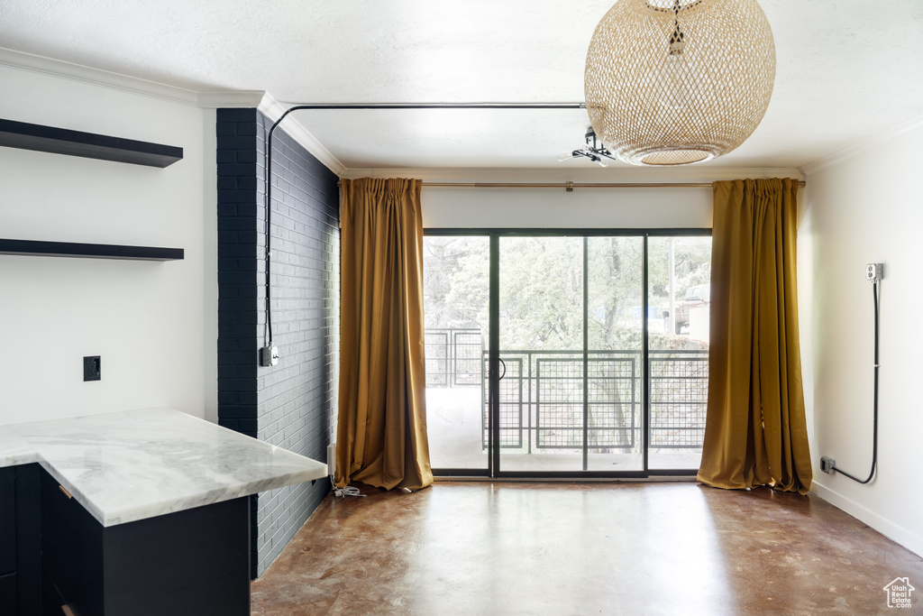 Interior space featuring finished concrete floors, baseboards, and ornamental molding