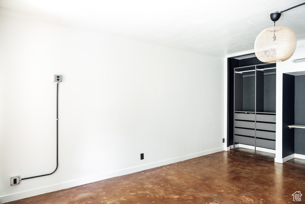 Unfurnished bedroom featuring finished concrete flooring and baseboards