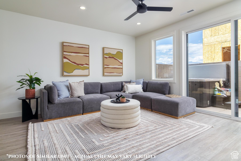 Living room with wood-type flooring and ceiling fan